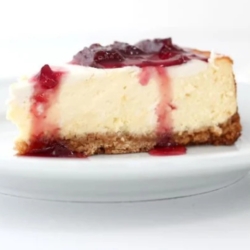 A slice of New York cheesecake on a white plate