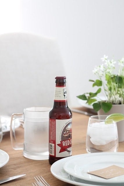 Beer and flowers on a table.