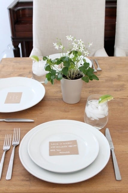 A drink and a vase of flowers on the table.