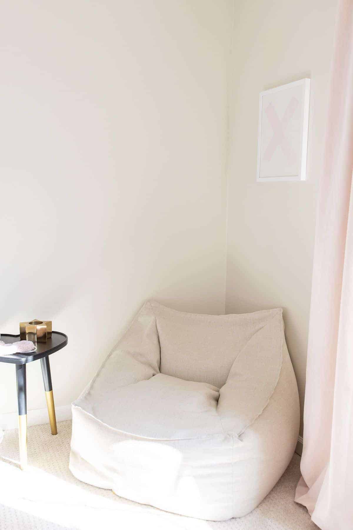 A tween bedroom idea of a white lounge chair in the corner of a tween bedroom.