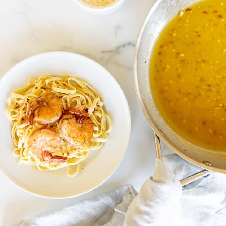 pasta with shrimp next to wine sauce in saucepan
