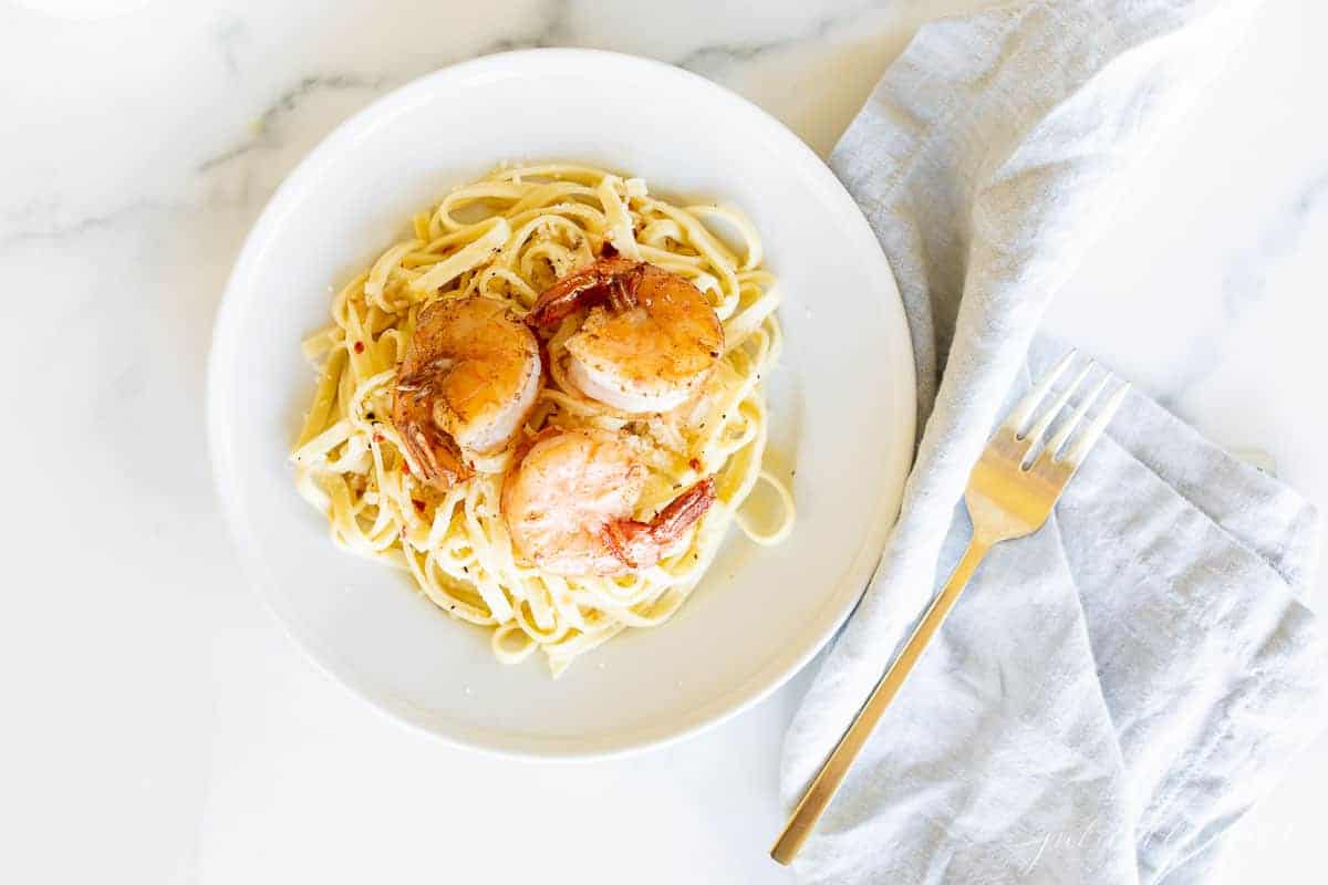 shrimp on bed of pasta with white wine sauce
