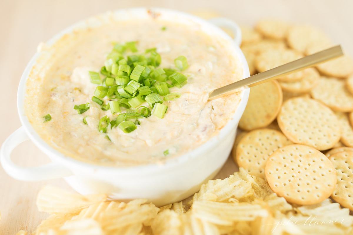 bacon cheese dip surrounded by chips and crackers for a Christmas appetizer