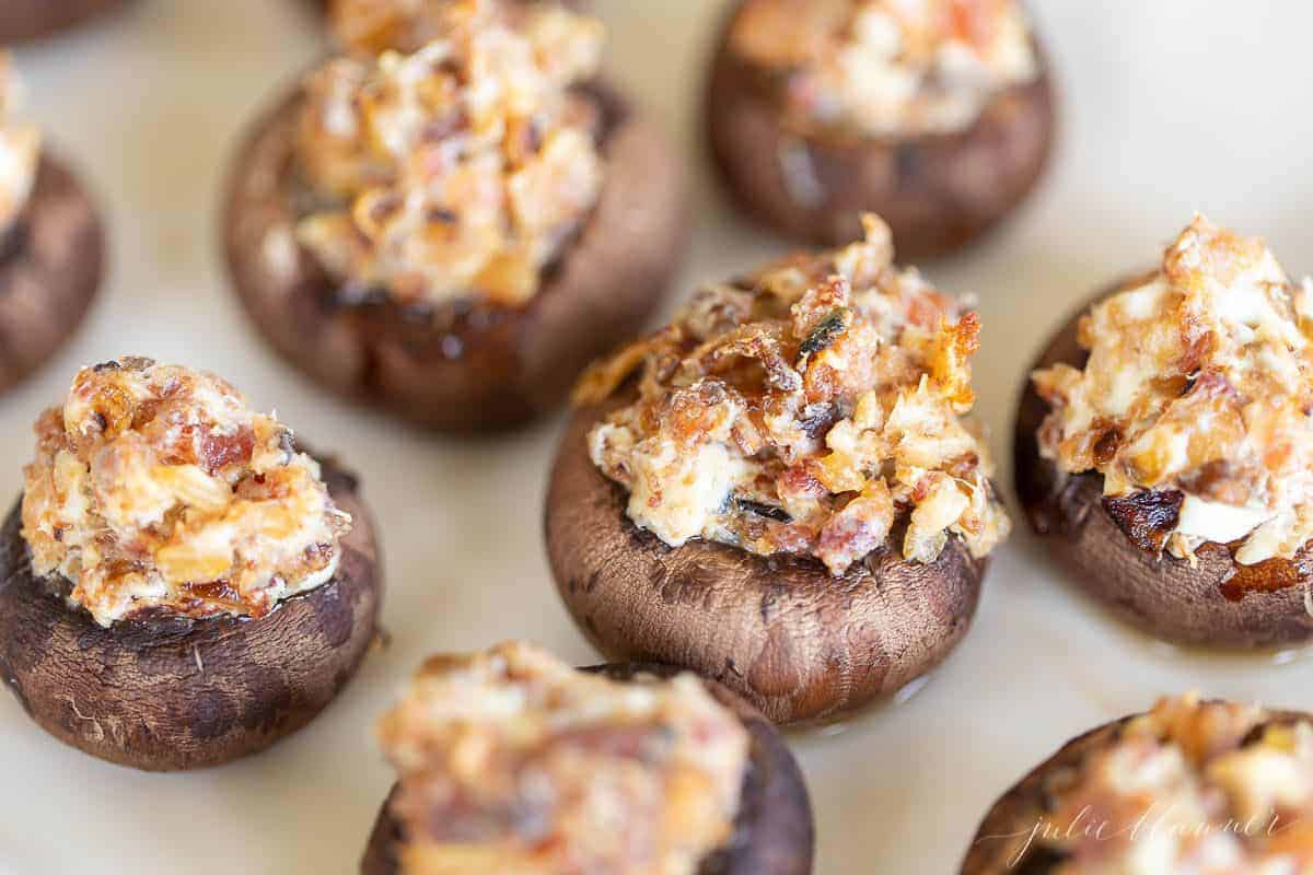 Bacon stuffed mushrooms on a white surface.