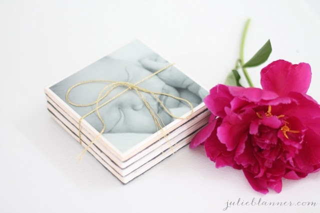 A close up of a flower next to photo coasters.