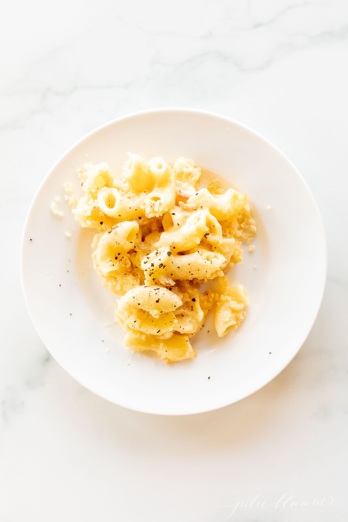 Delicious macaroni and cheese on a white plate, made using a baked mac and cheese recipe.