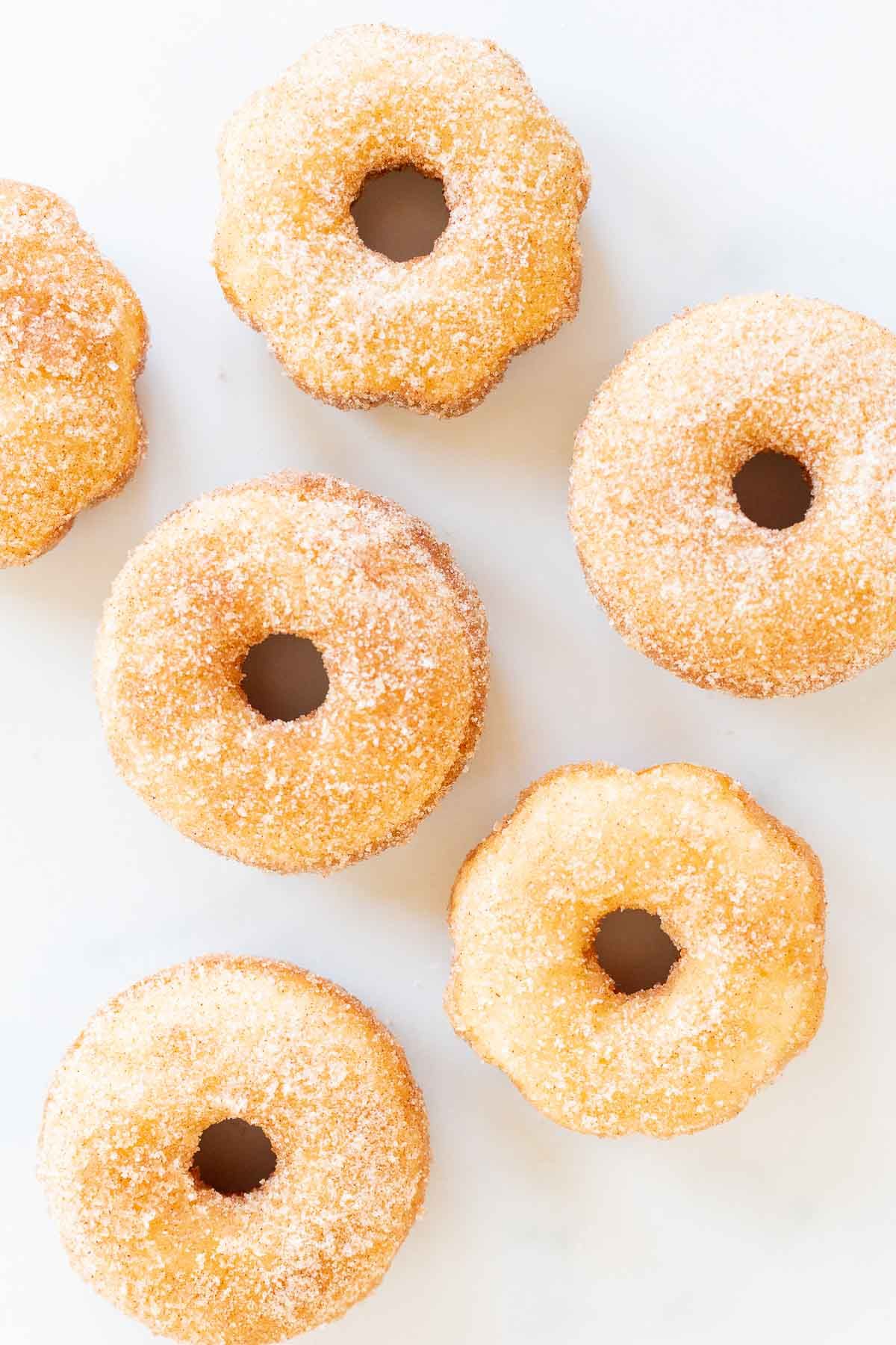 Cinnamon sugar donuts on a marble countertop.