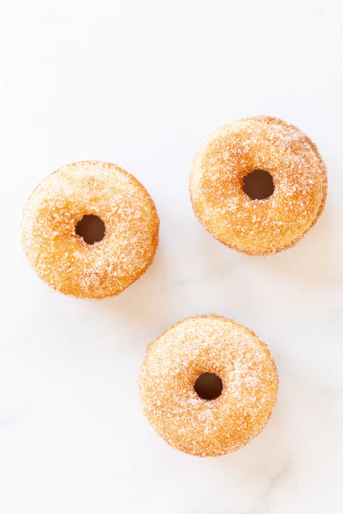 Cinnamon sugar donuts on a marble countertop.