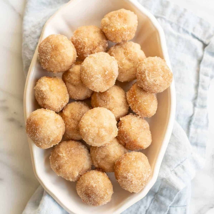 cinnamon muffins in serving dish on blue napkin