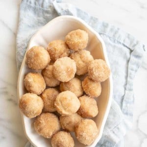 cinnamon muffins in serving dish on blue napkin