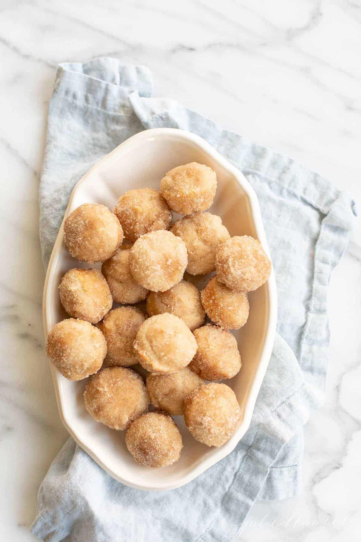 cinnamon muffins in serving dish on blue napkin