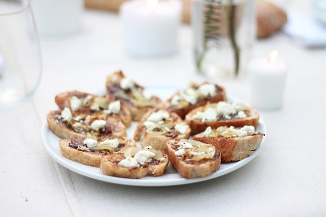 Goats cheese crostini appetizers served on a white plate