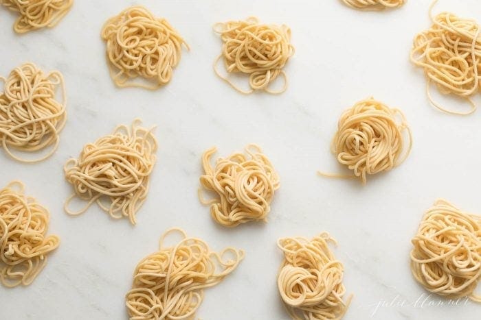 Piles of pasta on a marble surface.