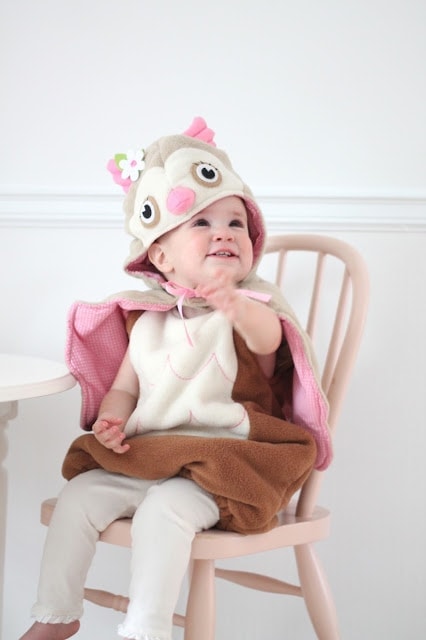 A baby sitting in a chair in a costume