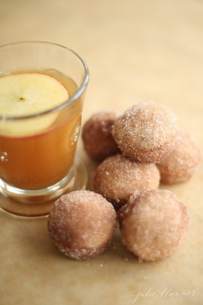 apple cider donut holes with apple cider in a glass