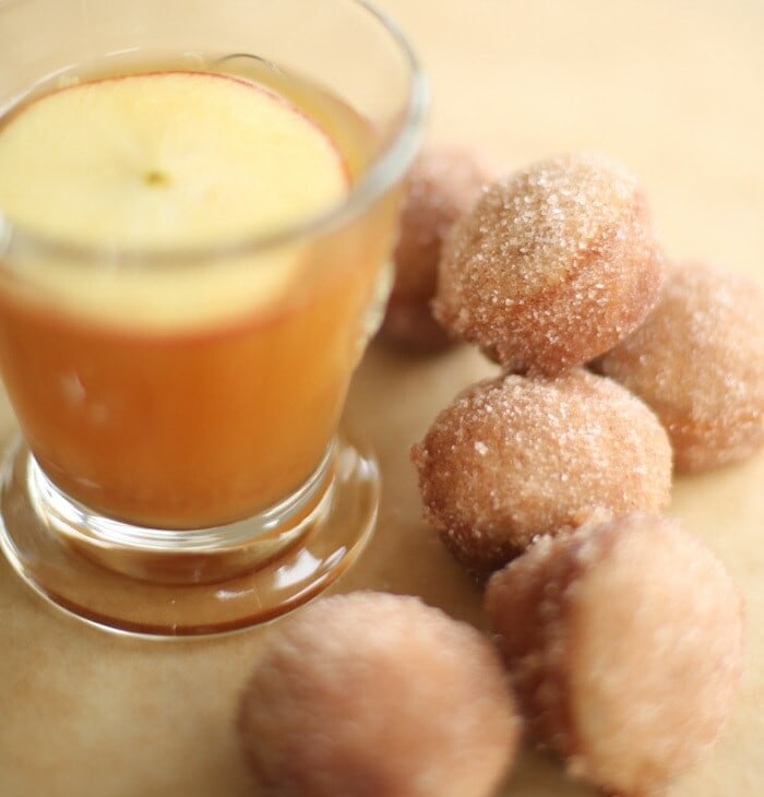 apple cider donut holes with apple cider in a glass