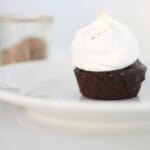A single serving of a hot chocolate cake topped with meringue on a white plate.