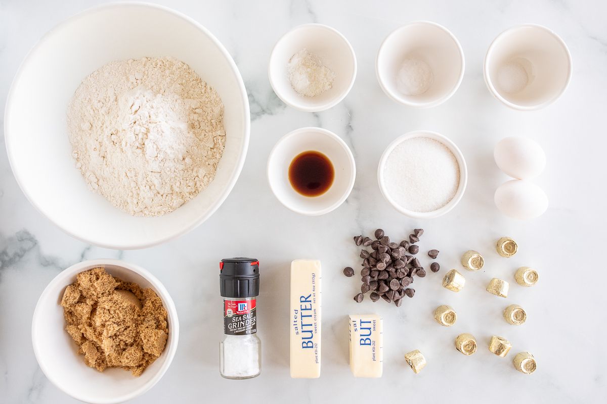 Ingredients for salted caramel chocolate chip cookies on a marble countertop.