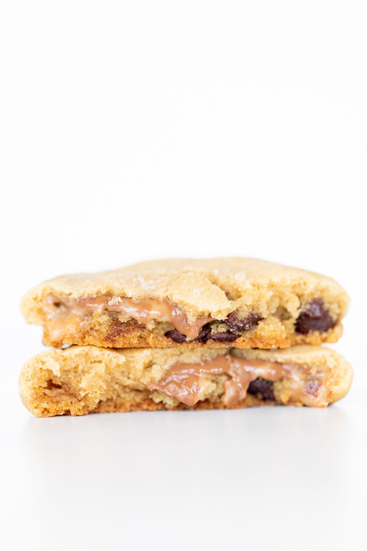 A salted caramel chocolate chip cookie, broken into two pieces.
