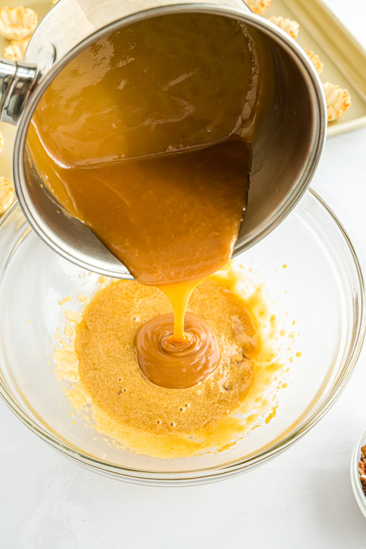 Caramel sauce being poured over a Mini Pecan Pie.