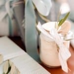 milk bath in a jar with a ribbon wooden spoon and olive branch garnish