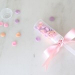colorful sprinkles scattered and plastic confetti popper with a ribbon