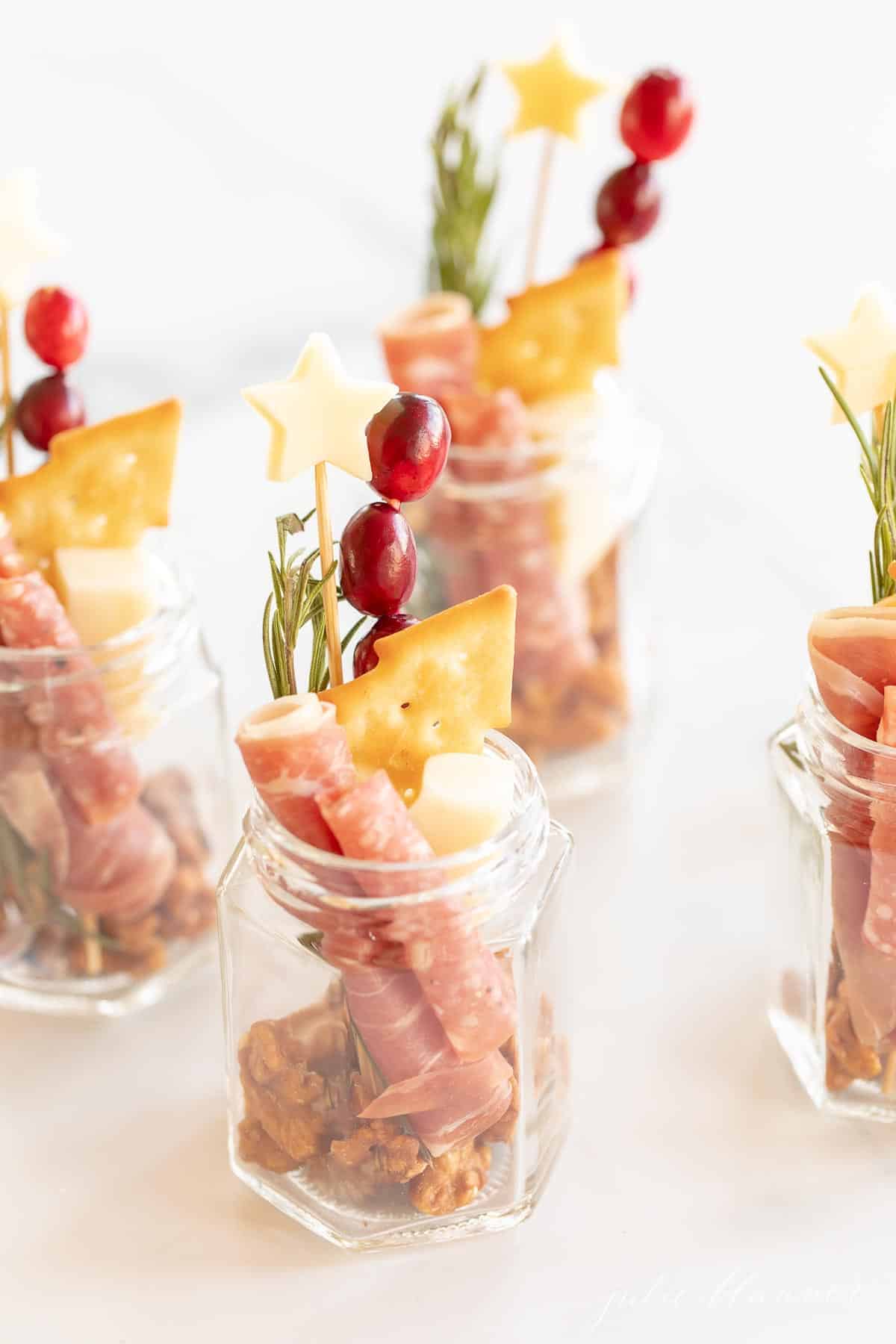 jars filled with charcuterie garnished with heart cheese and christmas cracker