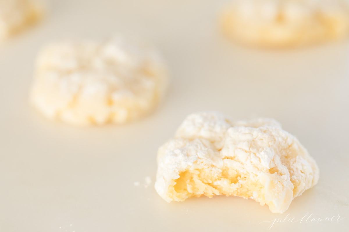 A gooey butter cookie with a bite out of it on a white surface.