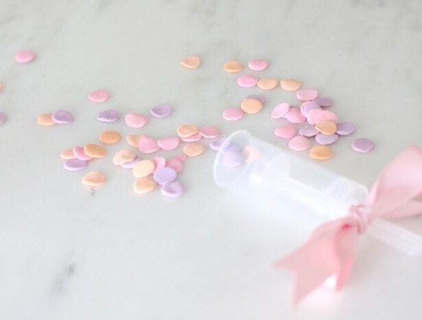 confetti popper with sprinkles and ribbon on marble surface