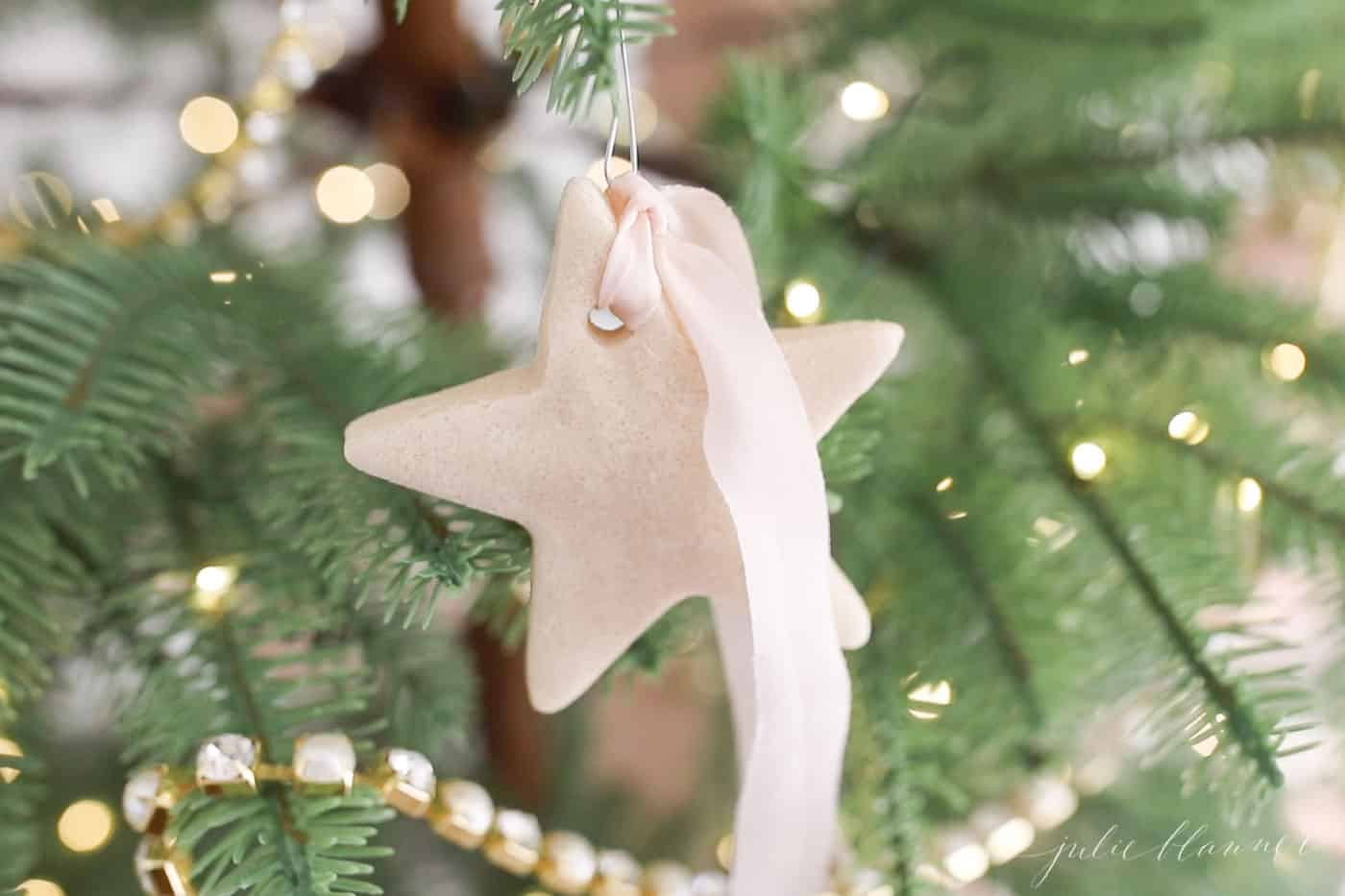 salt dough ornament in the shape of a start hanging on a christmas tree