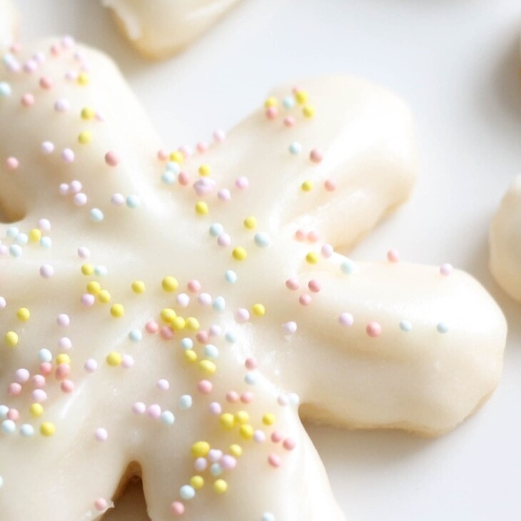 snowflake cookies covered in buttercream icing and sprinkles