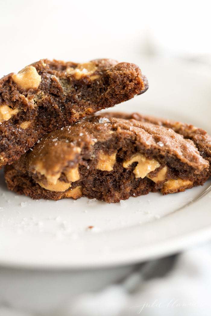 Peanut Butter Chip Chocolate Cookies cut in half on white plate