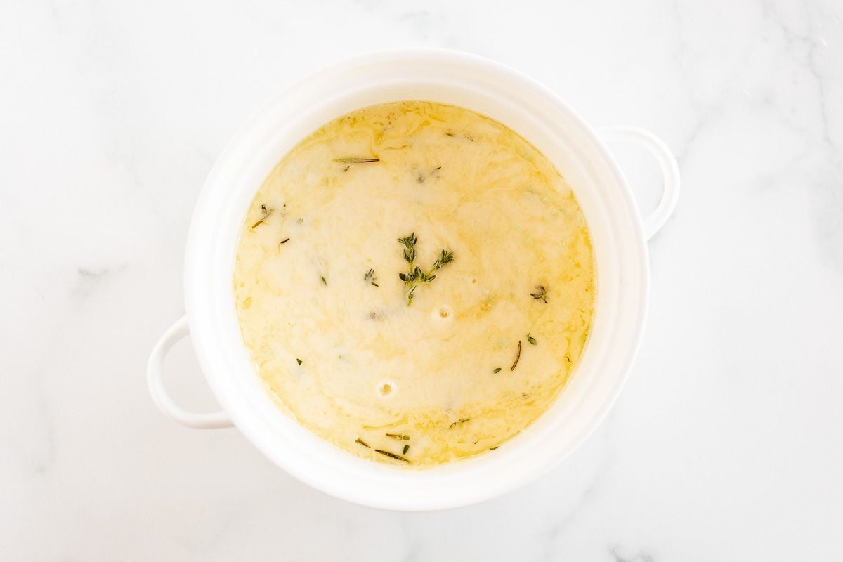 A white bowl of baked fontina cheese dip