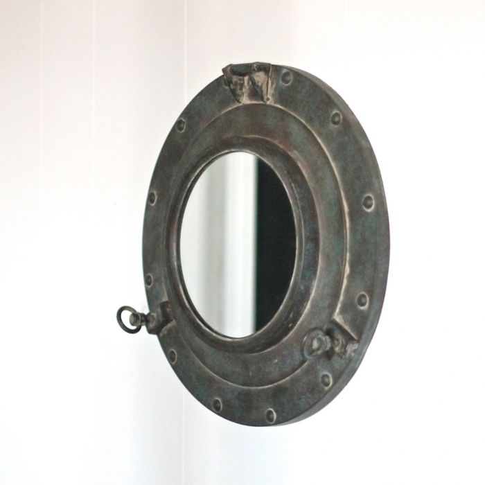 A close up of a mirror against a white wall.