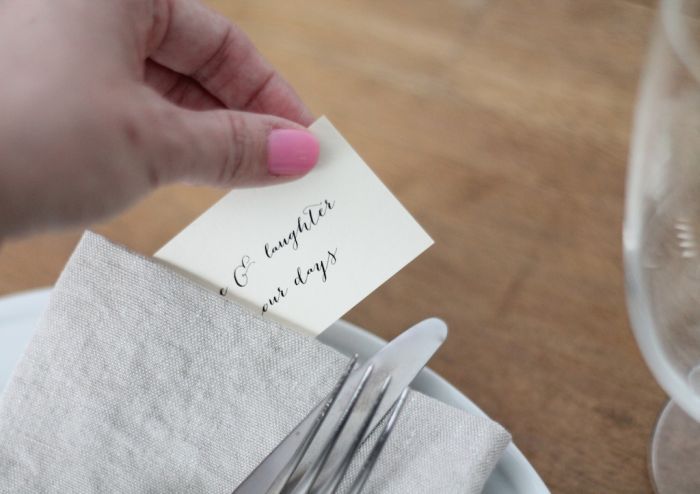 A fork and a knife tied together with ribbon. A small note is to the side.