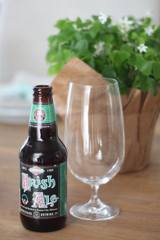 A close up of a bottle of beer and a glass on a table.