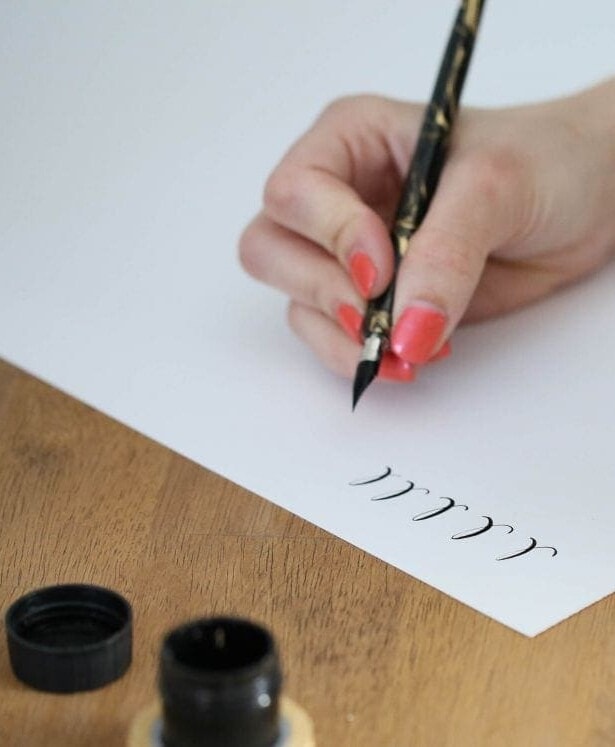 A woman practicing the calligraphy alphabet.