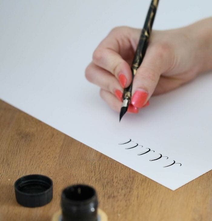 A woman practicing the calligraphy alphabet.