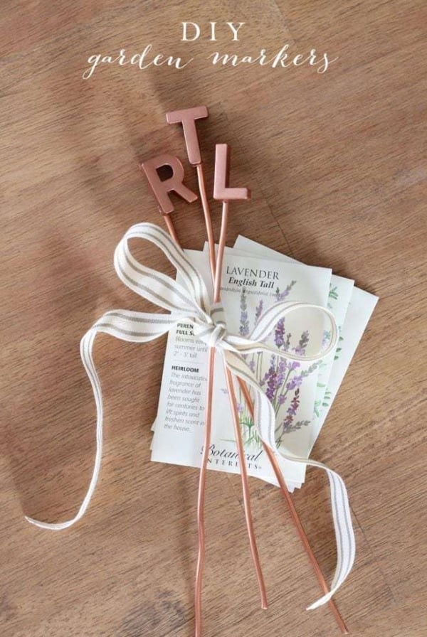 Three copper letter markers tied together with a ribbon and plant seeds as well.