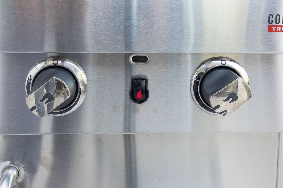 A stainless steel gas grill, image shot looking at knobs