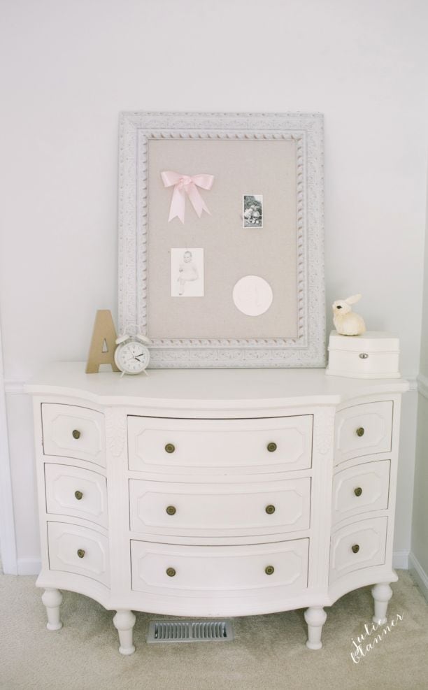 A white dresser in a white and pink little girls bedroom
