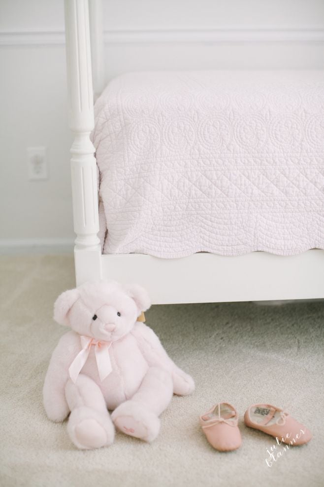 A stuffed animal sitting next to a bed
