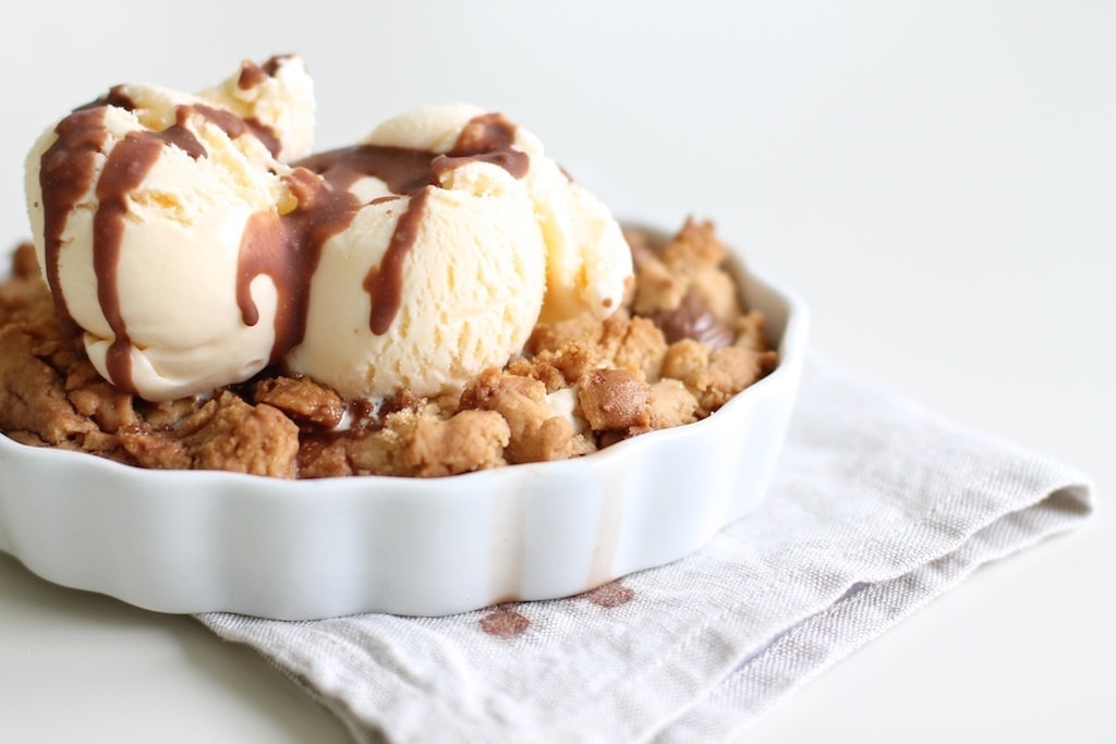 Peanut butter Cookie Cobbler in a creme brulee pan, topped with ice cream