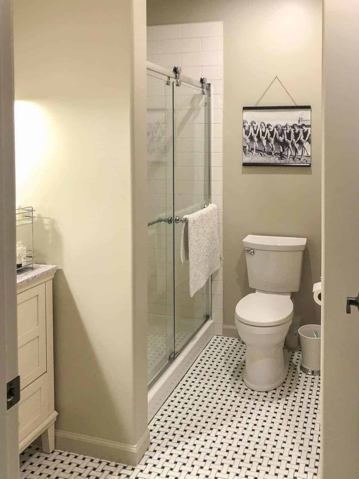 SW Accessible Beige in a small bathroom with a black and white vintage tile floor.