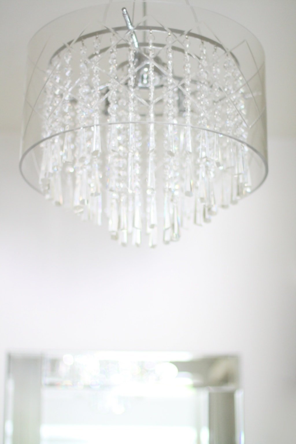 A bright glamorous silver chandelier inside a closet.