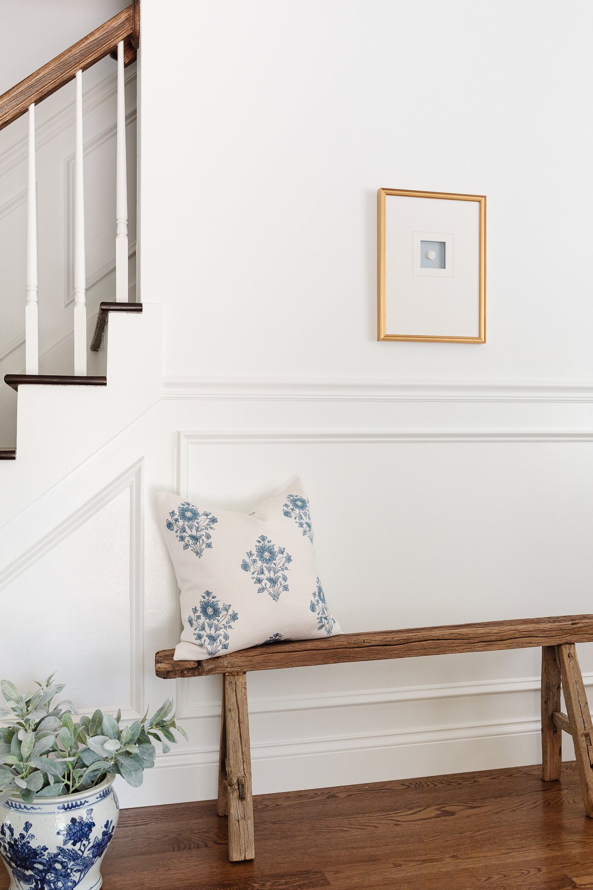 A staircase with a wooden bench in a foyer design.