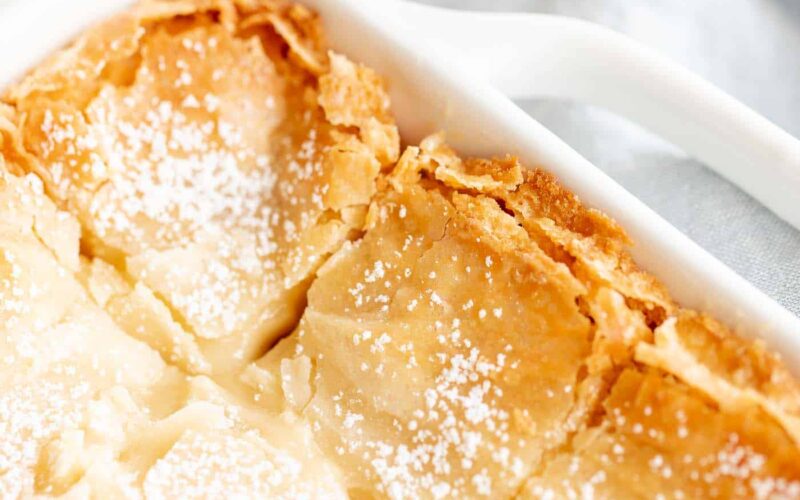 golden gooey butter cake with brown butter in white baking dish