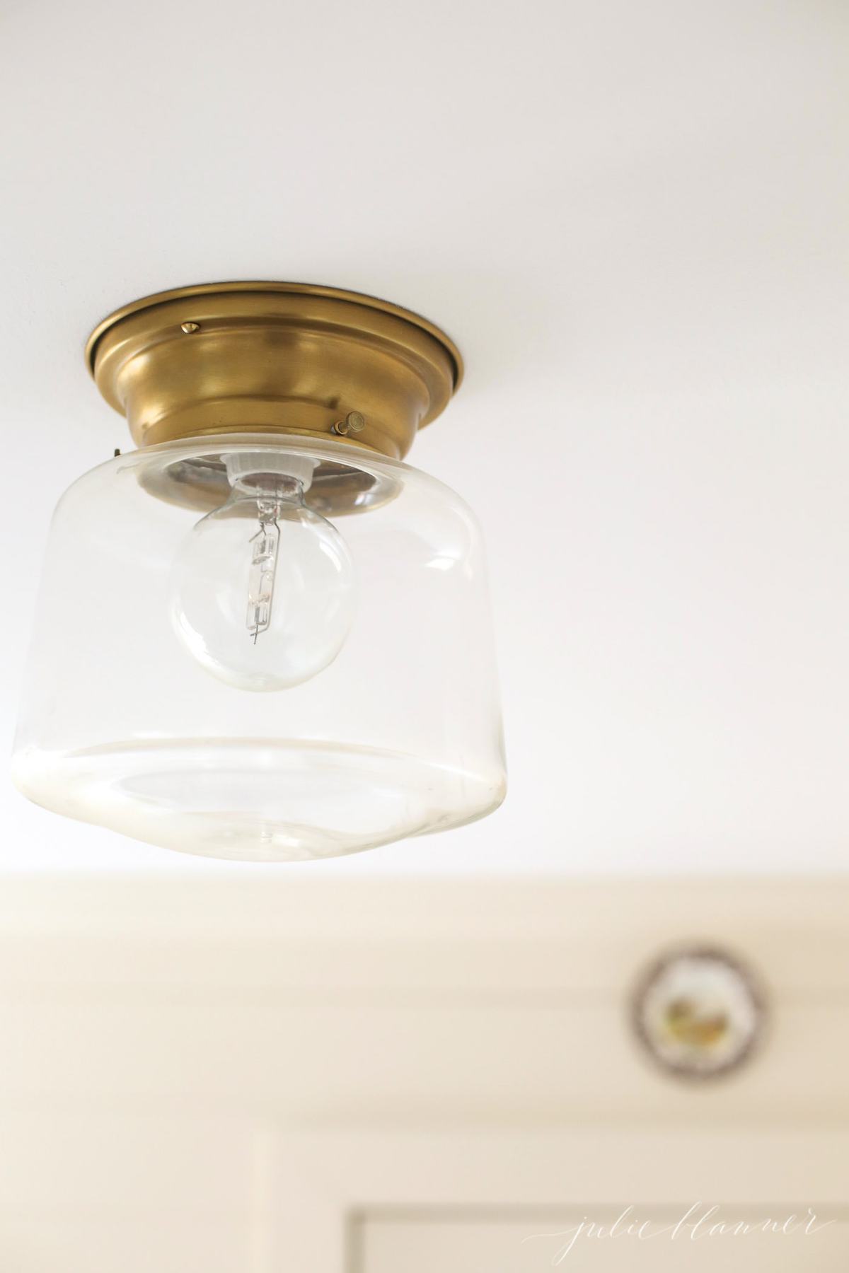 A light fixture with a gold base and glass surrounding.