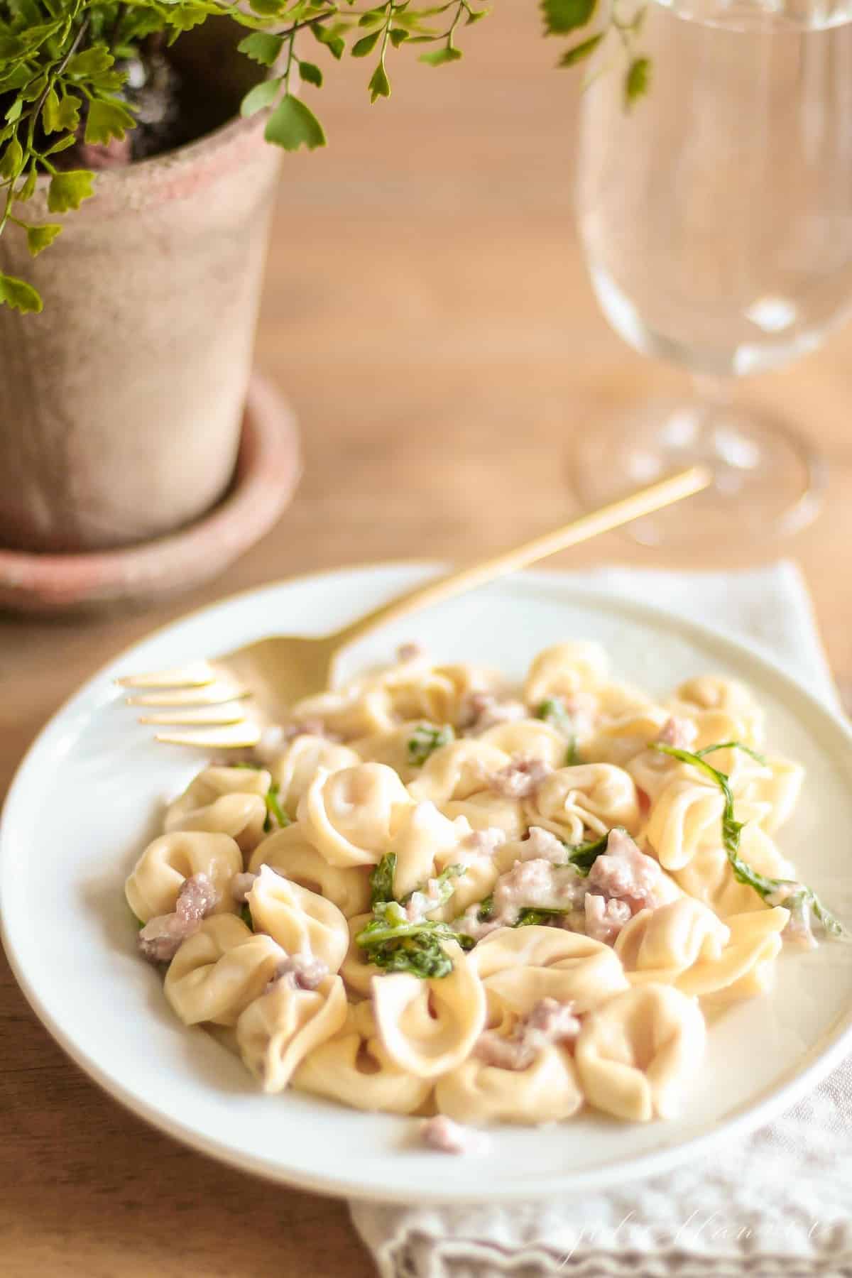 maggianos tortellacci on a white plate with gold fork on top of linen napkin