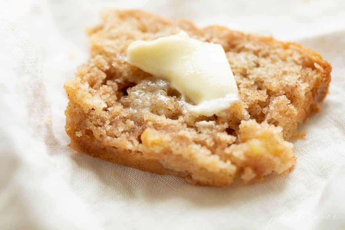 Slice of apple cinnamon bread with a pat of butter on top. 